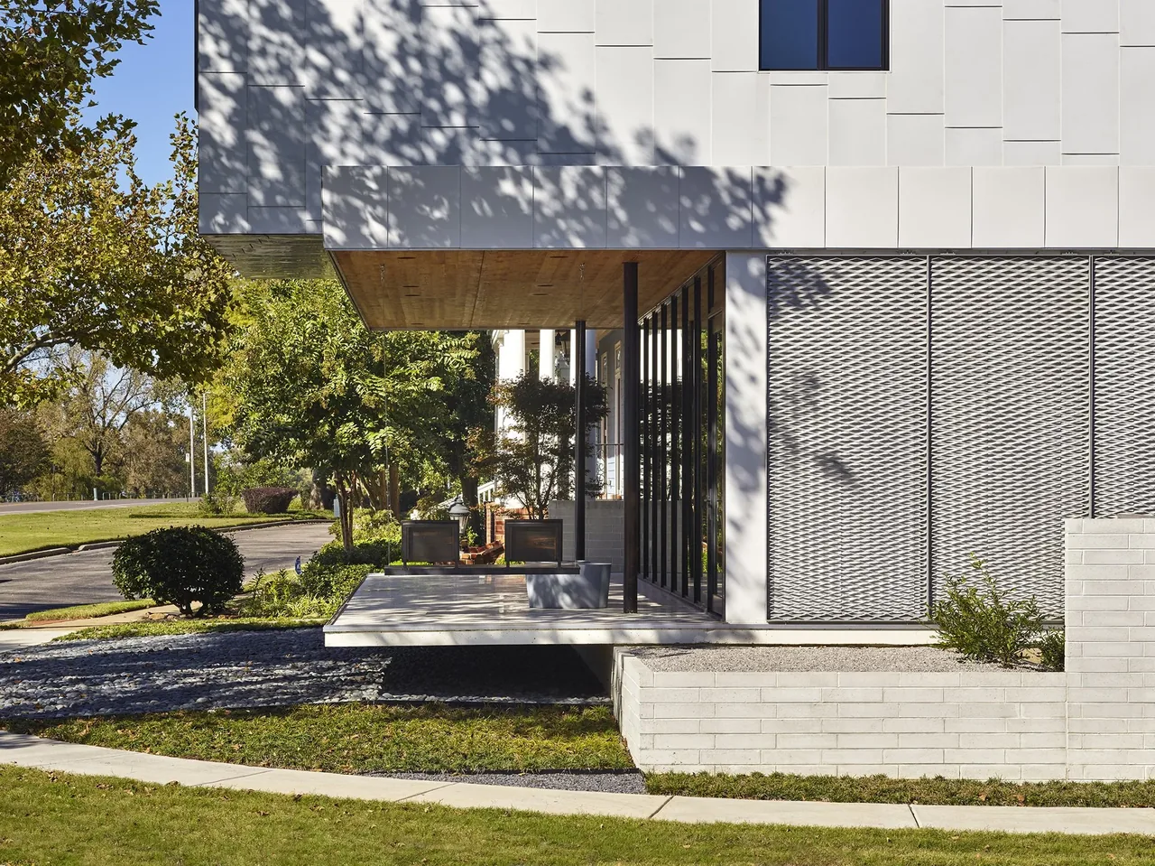 The Civitas project features a cube-shaped volume with a projecting suspended bench and a perforated metal facade panel.