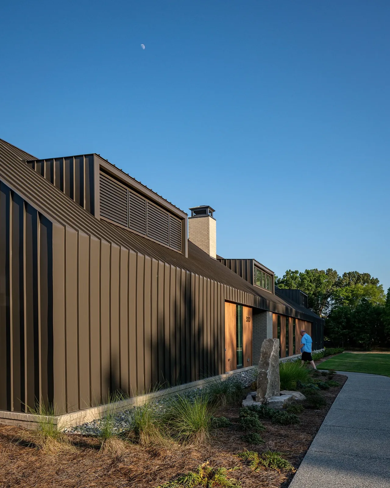 Fleetview Residence features dark standing seam metal siding and peaked roofs with vented dormers.