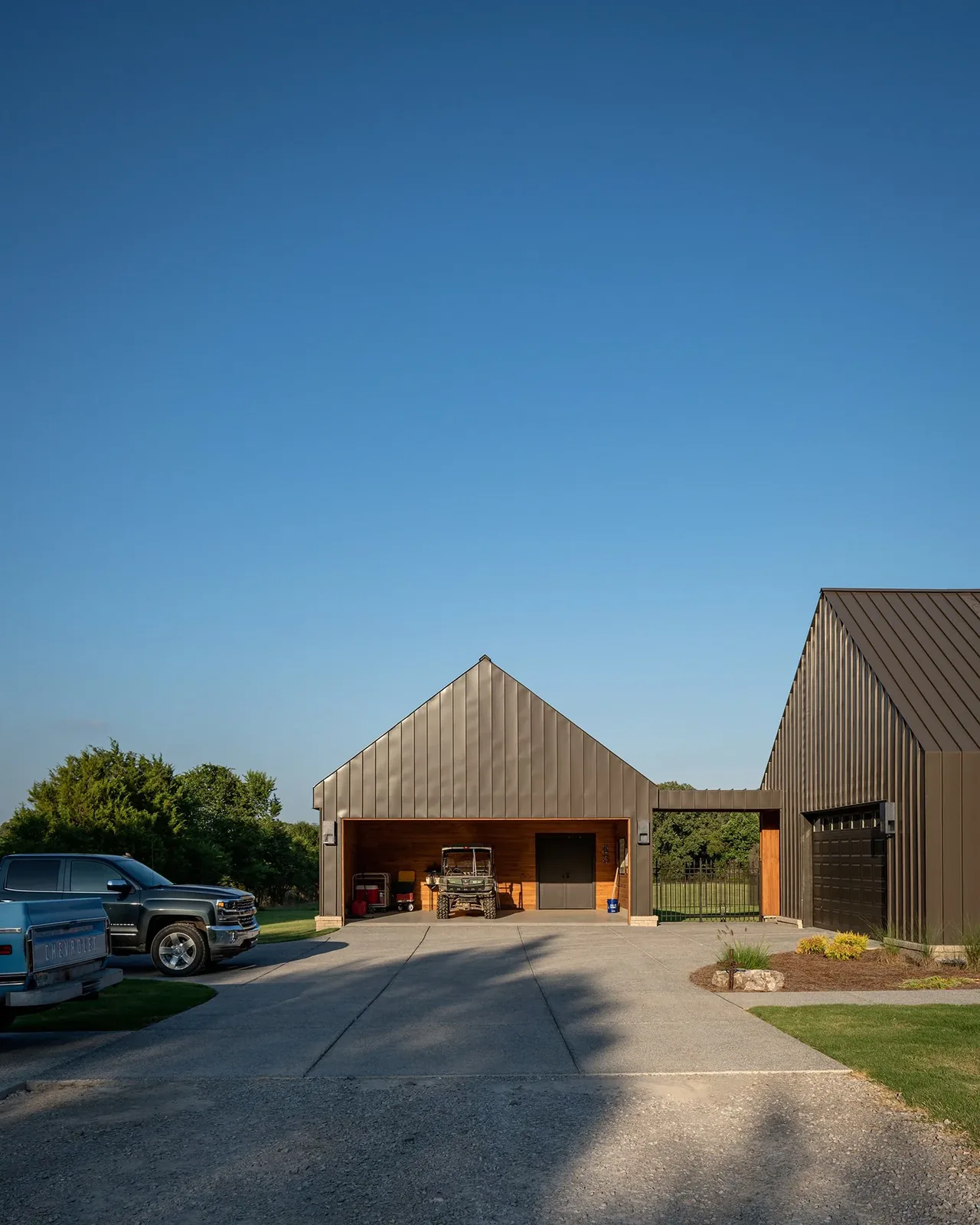 The Fleetview Residence features a garage with metal cladding and a concrete driveway under clear sky.