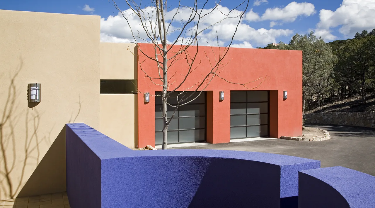 The Lehman project features an orange accent wall with garage doors and a curved blue privacy fence at the entry.