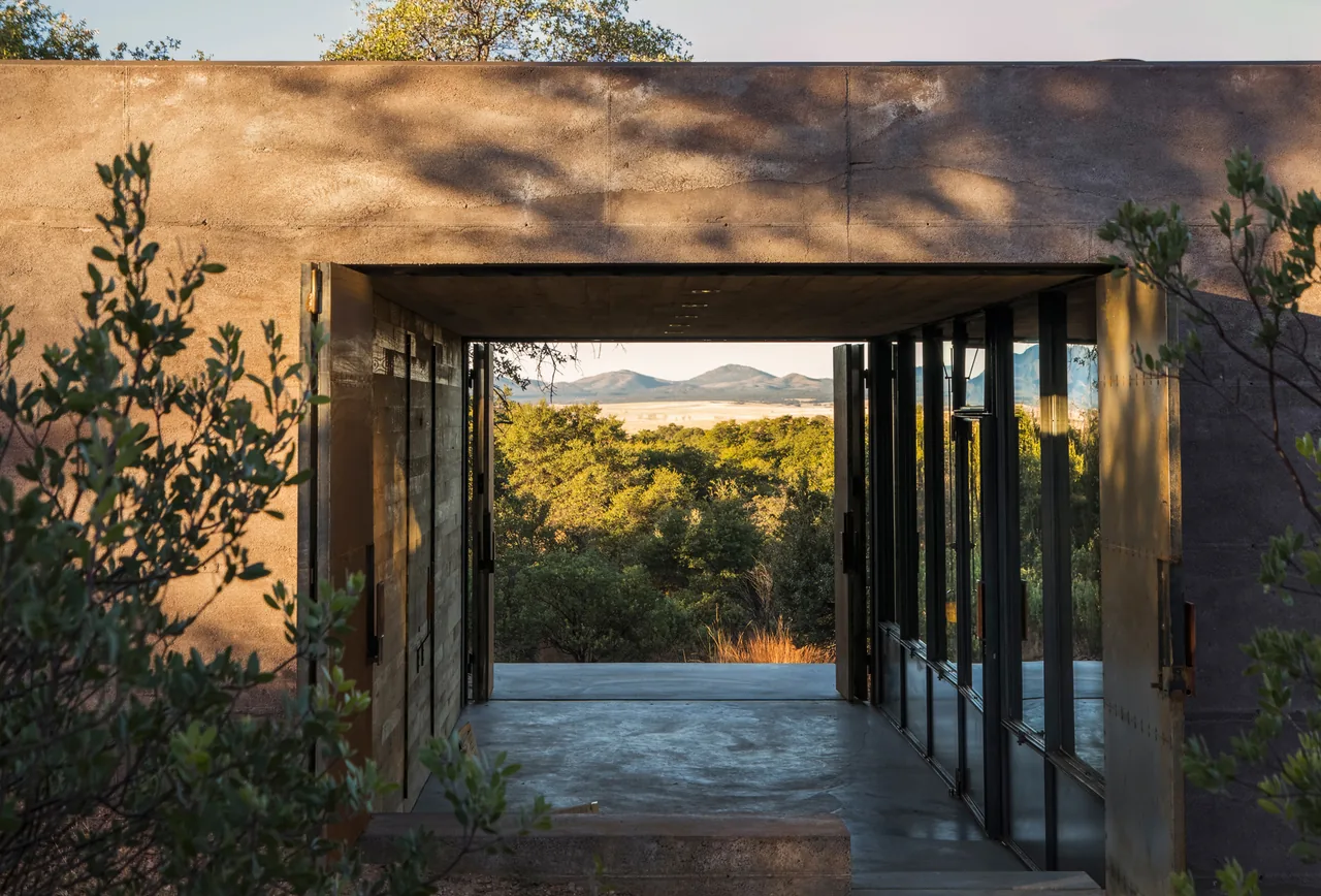 Casa Caldera features a rectangular opening framing nature views in a Phoenix desert setting.