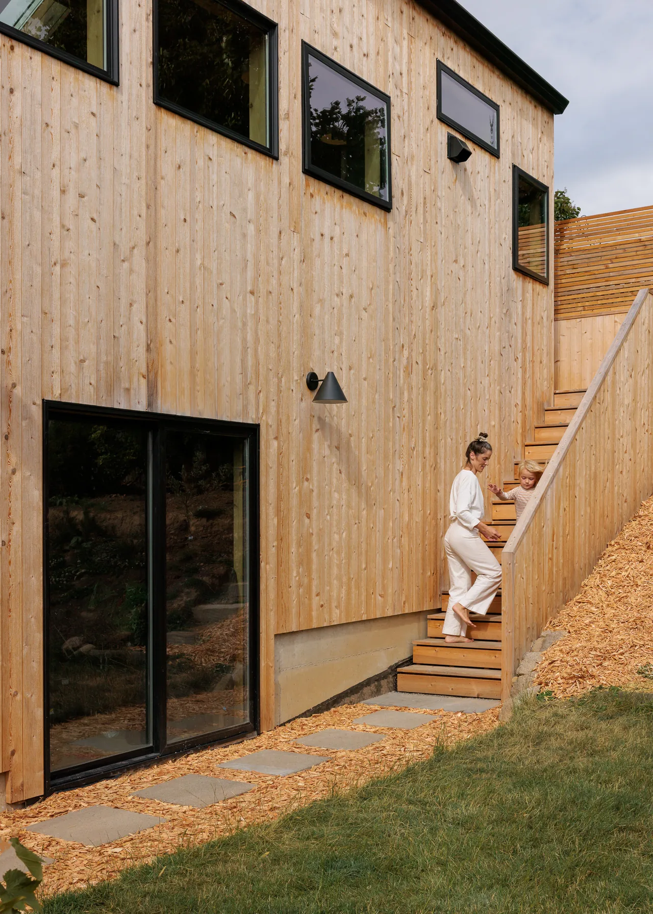 Moonwave DADU features vertical wood siding, black window frames, and a side staircase.