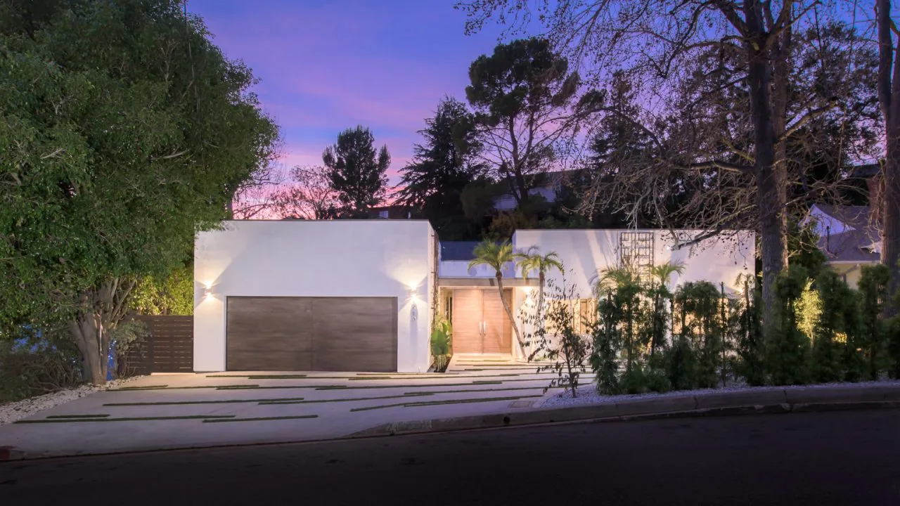 2213 Roscomare features a modern flat-roofed exterior with a wooden garage door and prominent front entrance at twilight.