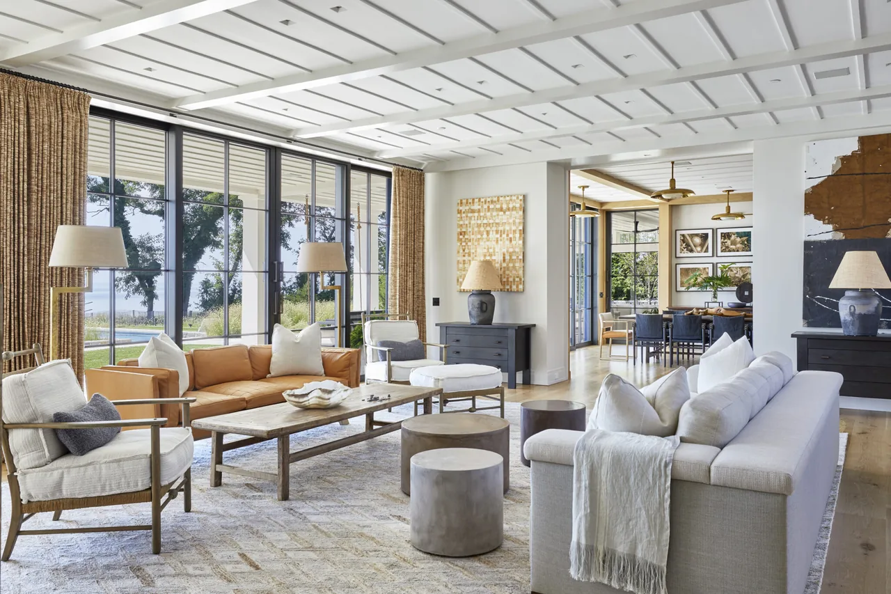 Living room featuring large floor-to-ceiling windows, a coffered ceiling, and a mix of wood and upholstered furniture.