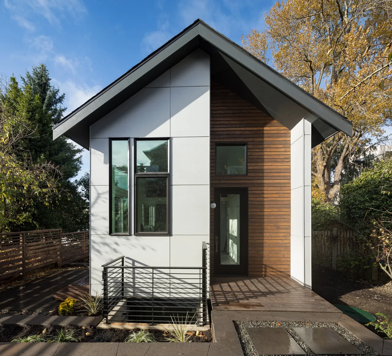 Project 335 DADU shows a modern small house with white panel and wood siding exterior in Seattle.