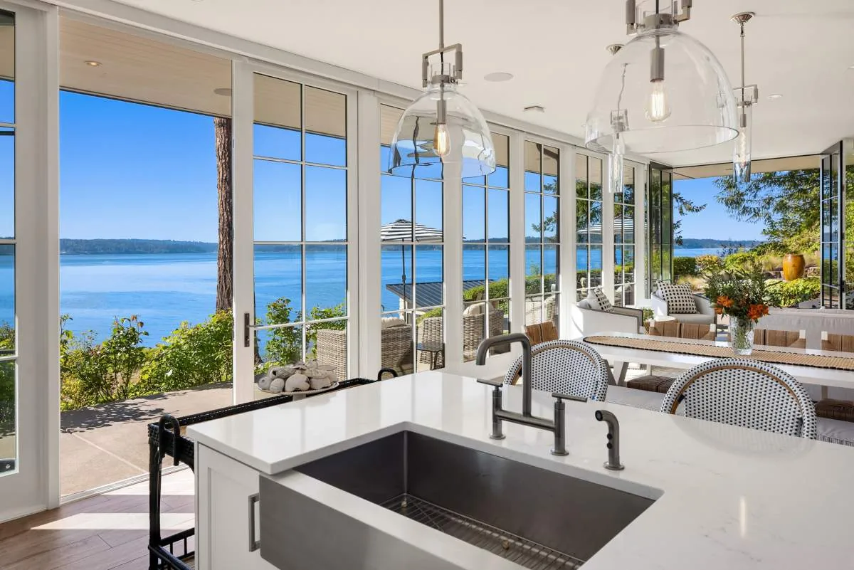 The Lafayette House features expansive glass doors providing water views and access from kitchen and dining areas to the patio.
