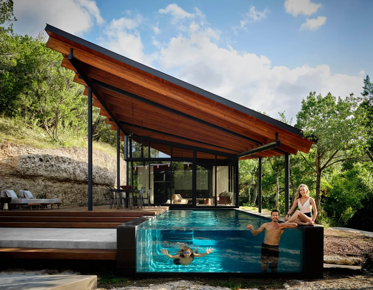 The Falling Leaves House features a pool with a glass wall and a covered patio with a wood soffit roof.