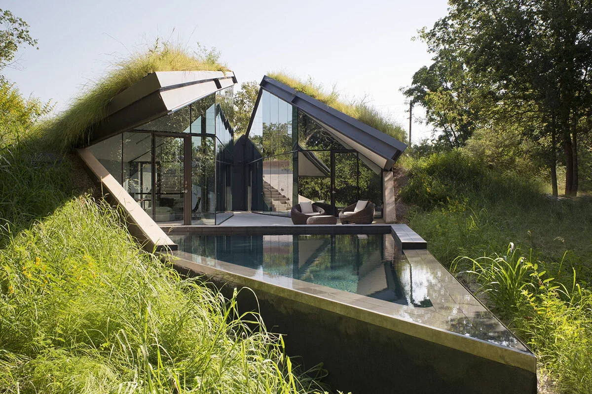 Bold Ruler House by Bercy Chen Studio features angled glass walls and green roofs around a pool in Austin.