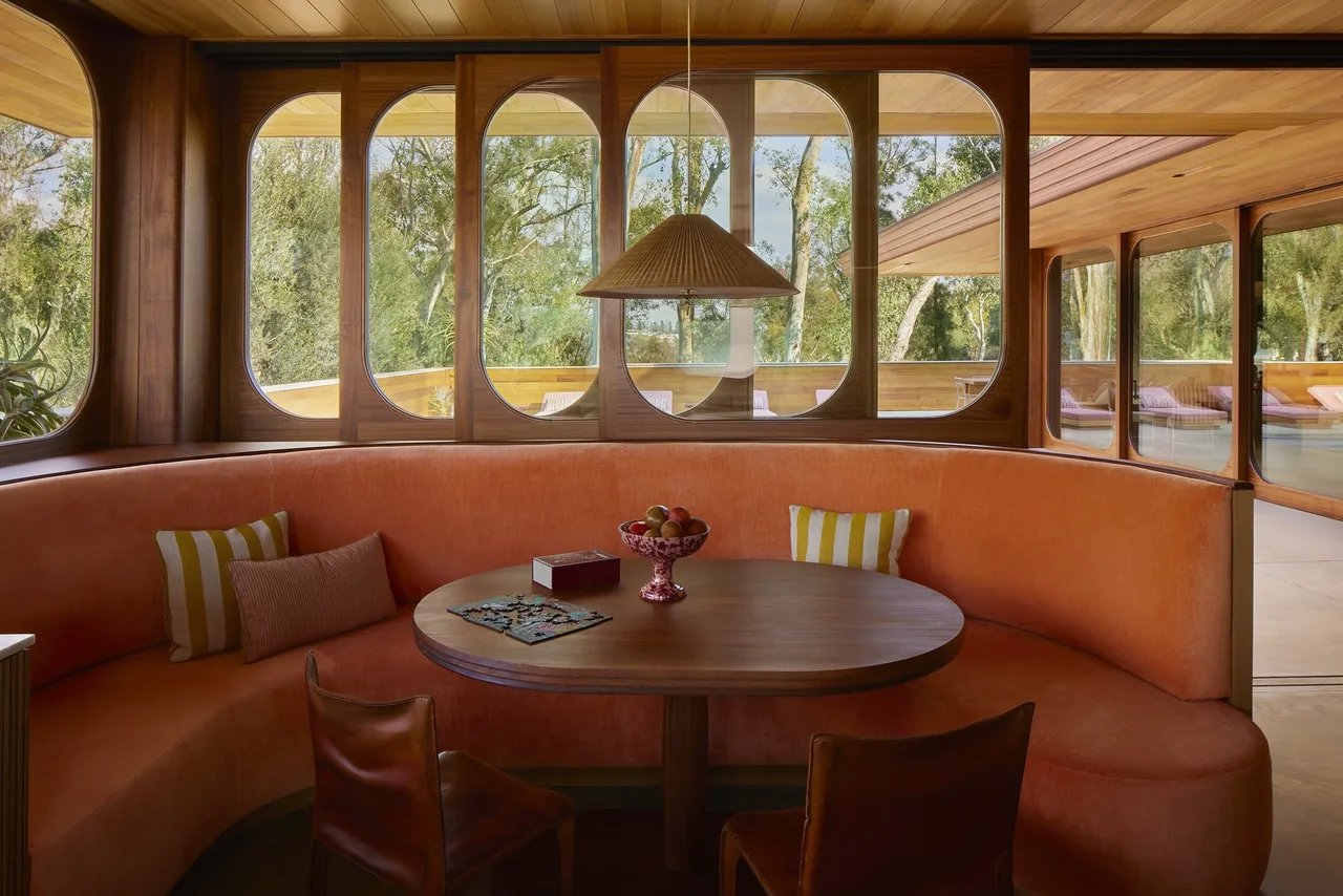 Curved banquette seating and a round wood table define the dining nook in the Claremont residence by Bestor Architecture.