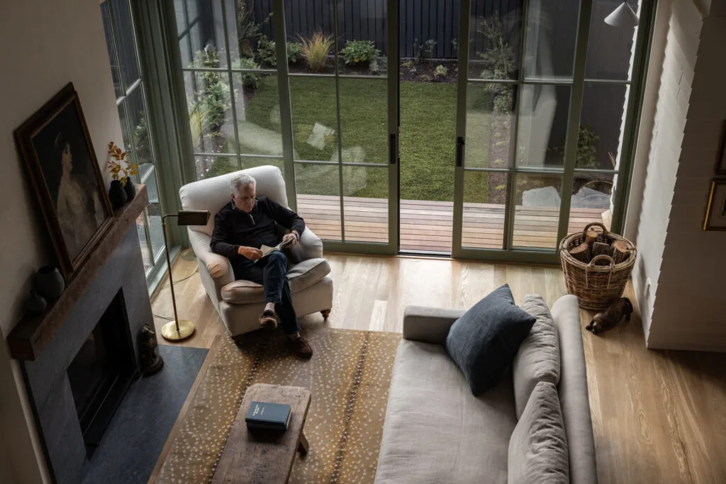 Living room with a fireplace, large sliding glass door, and a view to the backyard deck and lawn.