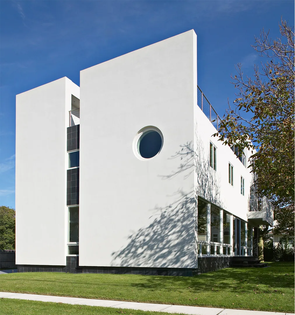 The Kowalewski Residence features a modern cubic design with prominent circular and rectangular windows.