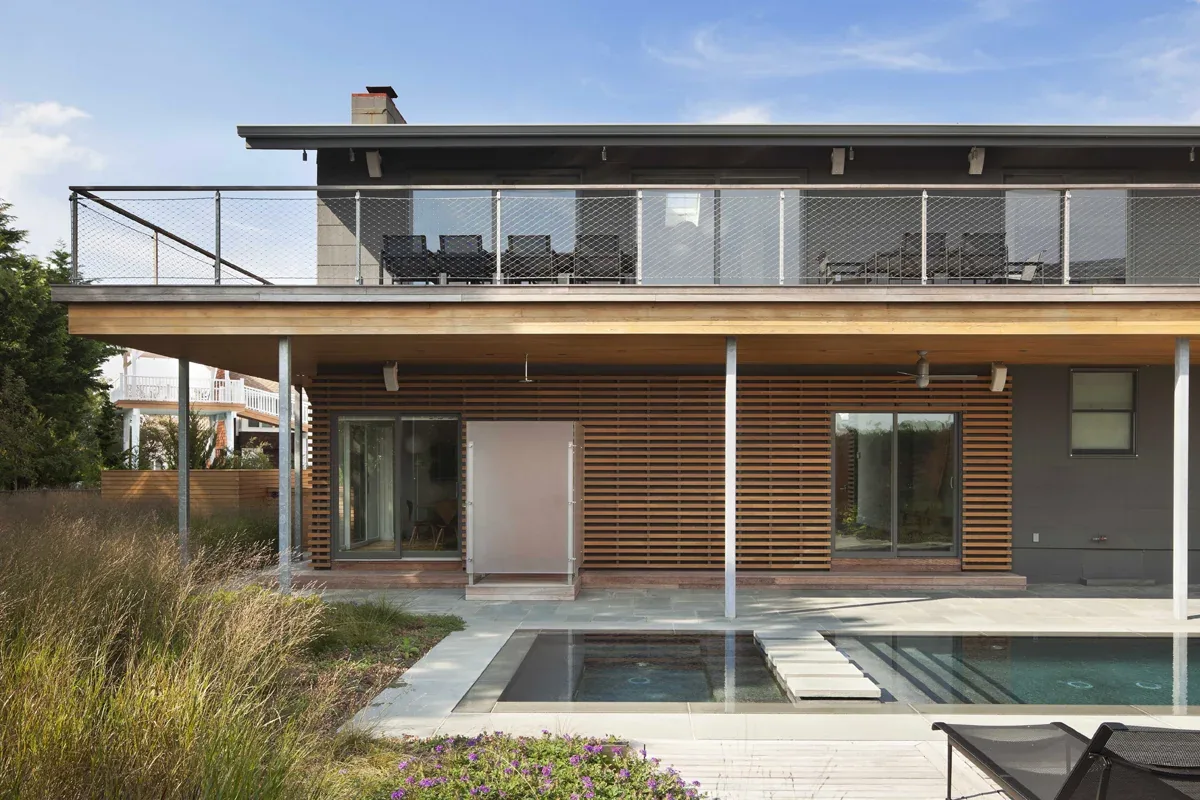 Exterior rear of Avalon NJ project showing wood slat screen and pool area under covered patio.