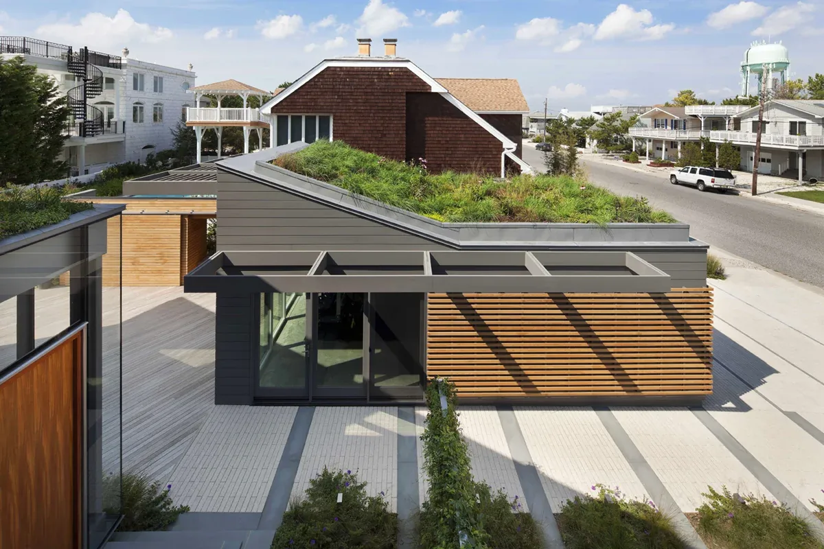 Modern flat roof building featuring a planted green roof and horizontal wood slat exterior paneling.