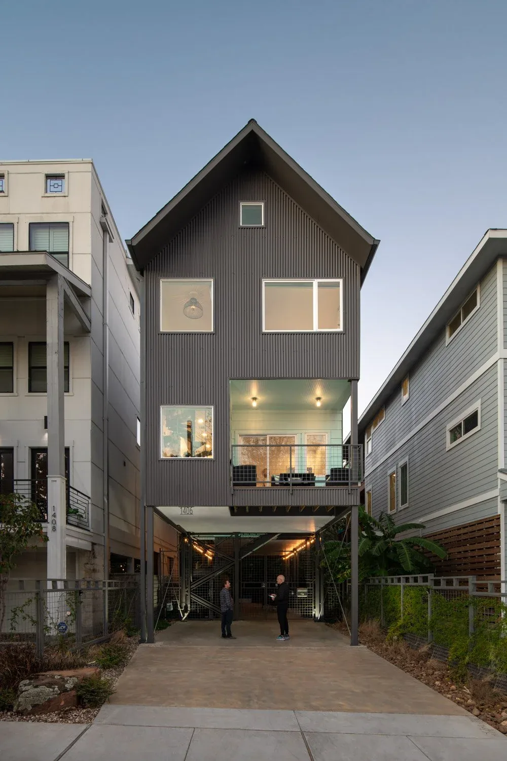 Saunders House by Brett Zamore Design features a narrow footprint with a steep gable roof and elevated outdoor living space.
