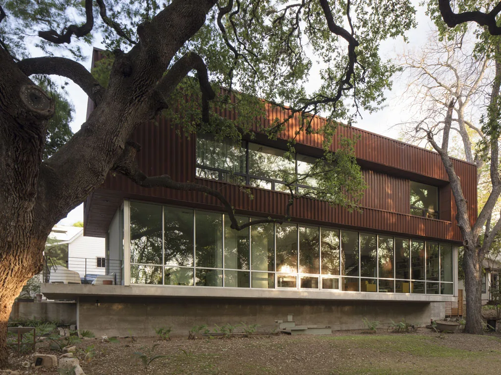 Bouldin 01 features a modern two-story design with extensive glazing on the ground floor and vertical siding above.