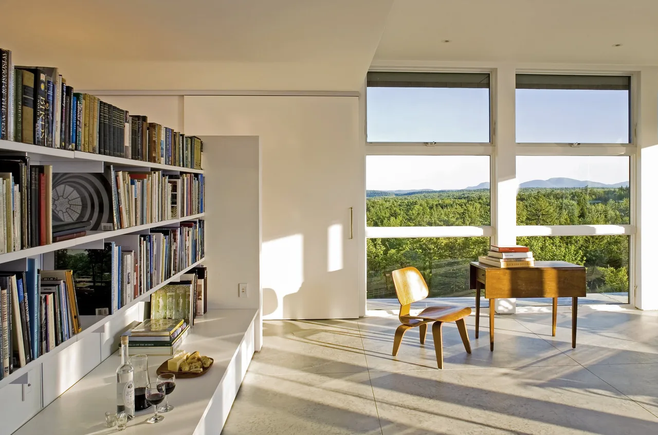 Punkinville House features a bright study area with floor-to-ceiling windows showcasing a scenic natural landscape.