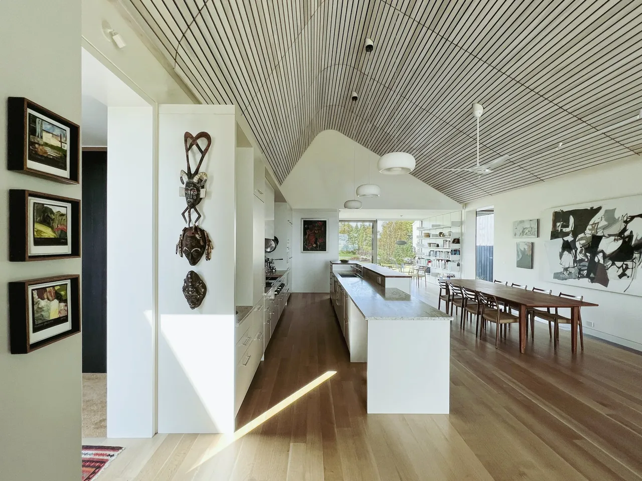 Howe Hill Crows Nest features an open kitchen and dining space with a vaulted ceiling and floor-to-ceiling windows.