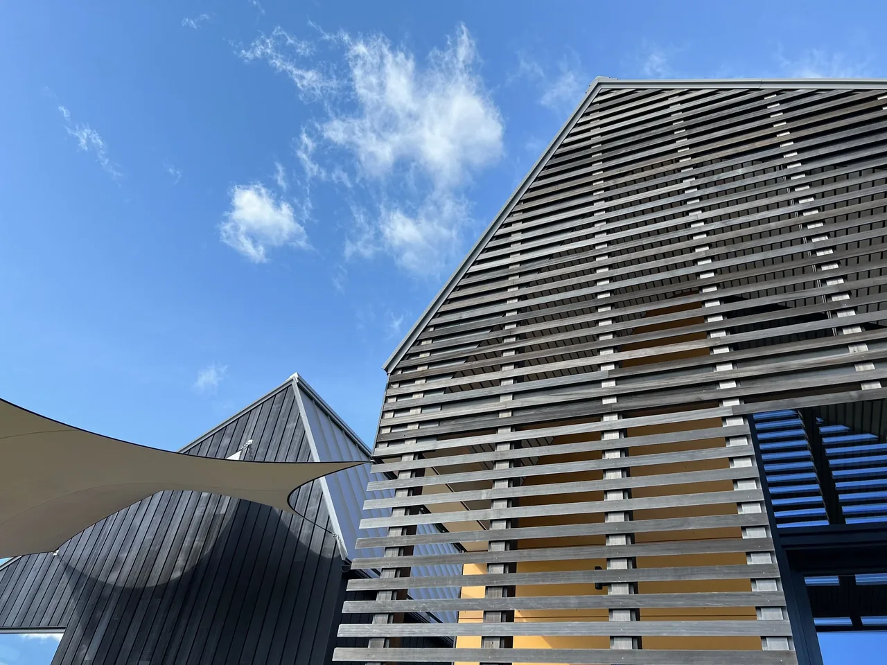 The Howe Hill Crows Nest features gable roofs with wood slat screens creating patterned shadows on the facade.