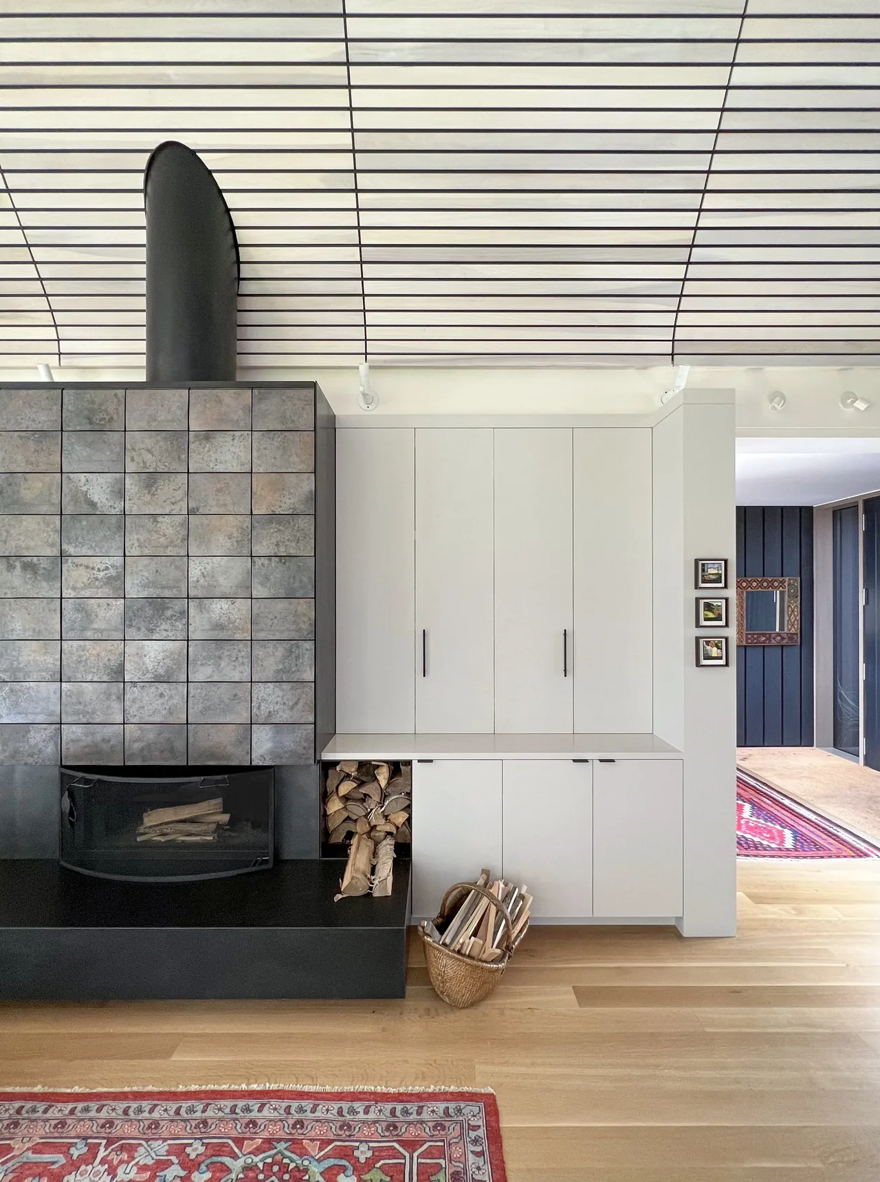 Fireplace with square tile facade and white built-in cabinetry in a modern styled interior room.