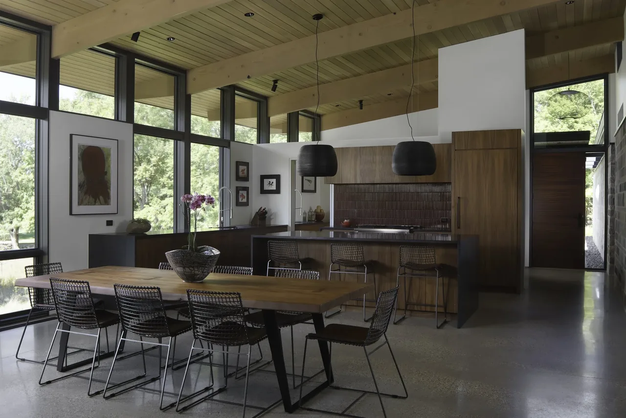 The Art & Music House kitchen and dining room feature floor-to-ceiling glazing and wood cabinetry.