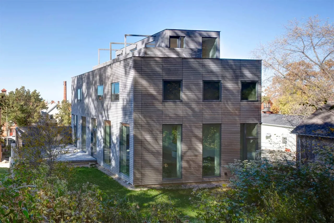 Fairview Townhouse II features a modern exterior with wood siding and square and tall rectangular windows.