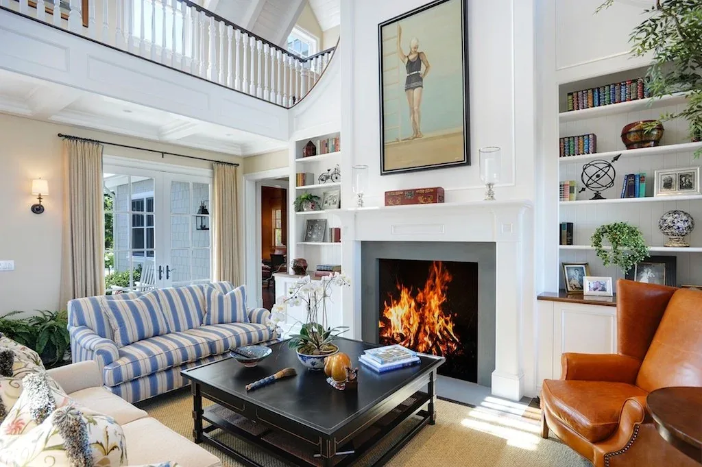 Traditional style living room featuring a fireplace with built-in shelving and double-height ceiling space.