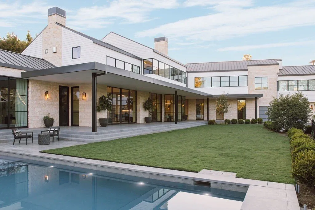 Malibu Modern by Burdge & Associates shows a blend of stone and metal roofs with a covered patio adjacent to pool and lawn.