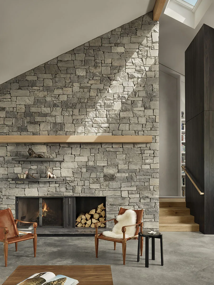 The Spring Creek Residence features a stone fireplace wall with built-in shelves and a skylight.