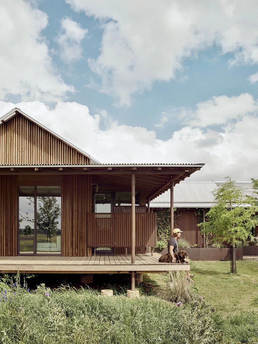 Rear exterior view of Roam Ranch showing raised wooden deck and vertical wood siding.