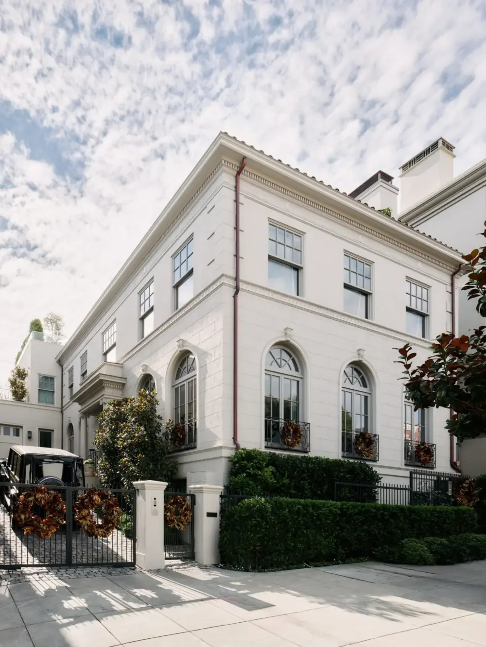 The Presidio Heights Residence features classical architectural elements with arched windows and decorative moldings on its white exterior.