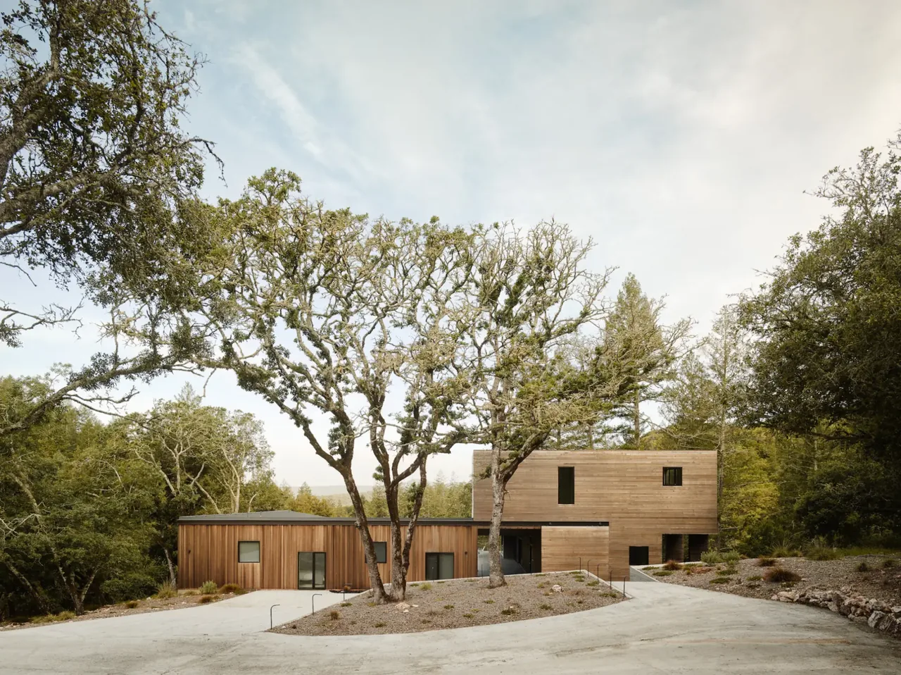 Valley of the Moon Retreat features wood siding and sits among mature trees with a concrete driveway.