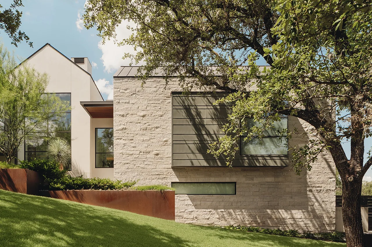 Rollingwood Modern features a stone and stucco exterior with flat and gable roofs, designed by James D. LaRue Architecture.