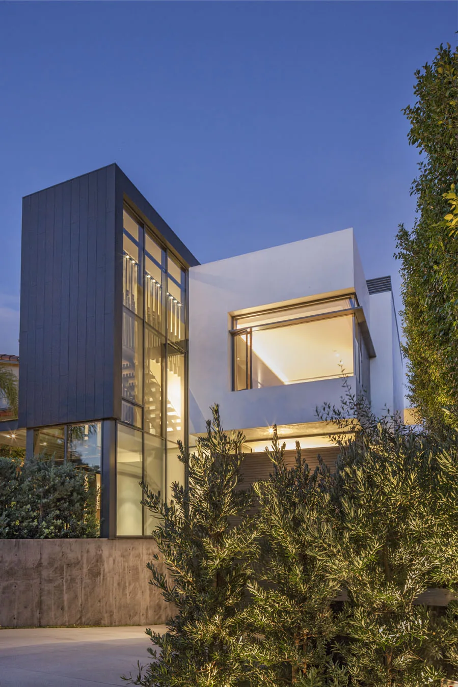 Exterior view of the Tower project showing a modern home with large vertical glass windows and contrasting dark siding.