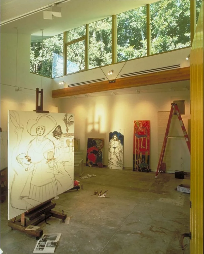 Yellow Studio interior features a high ceiling with clerestory windows and an art easel at center.