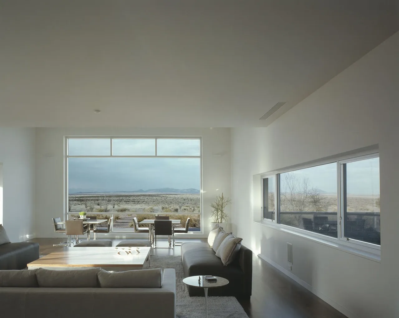 Living and dining spaces in Crowley House feature large and horizontal windows with expansive views of the surrounding arid landscape.
