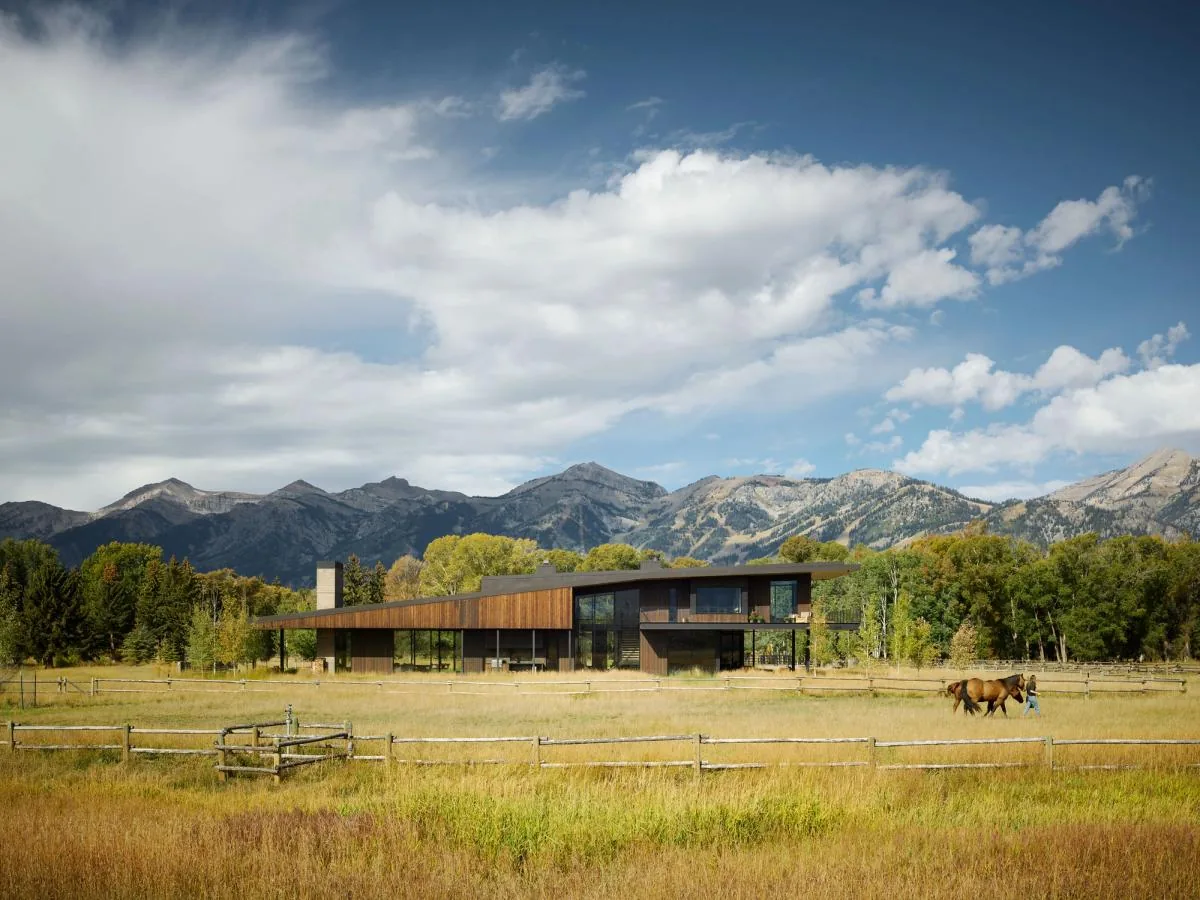 Black Fox Ranch by Carney Logan Burke Architects shows a modern house with a curved roof in a scenic mountain landscape.