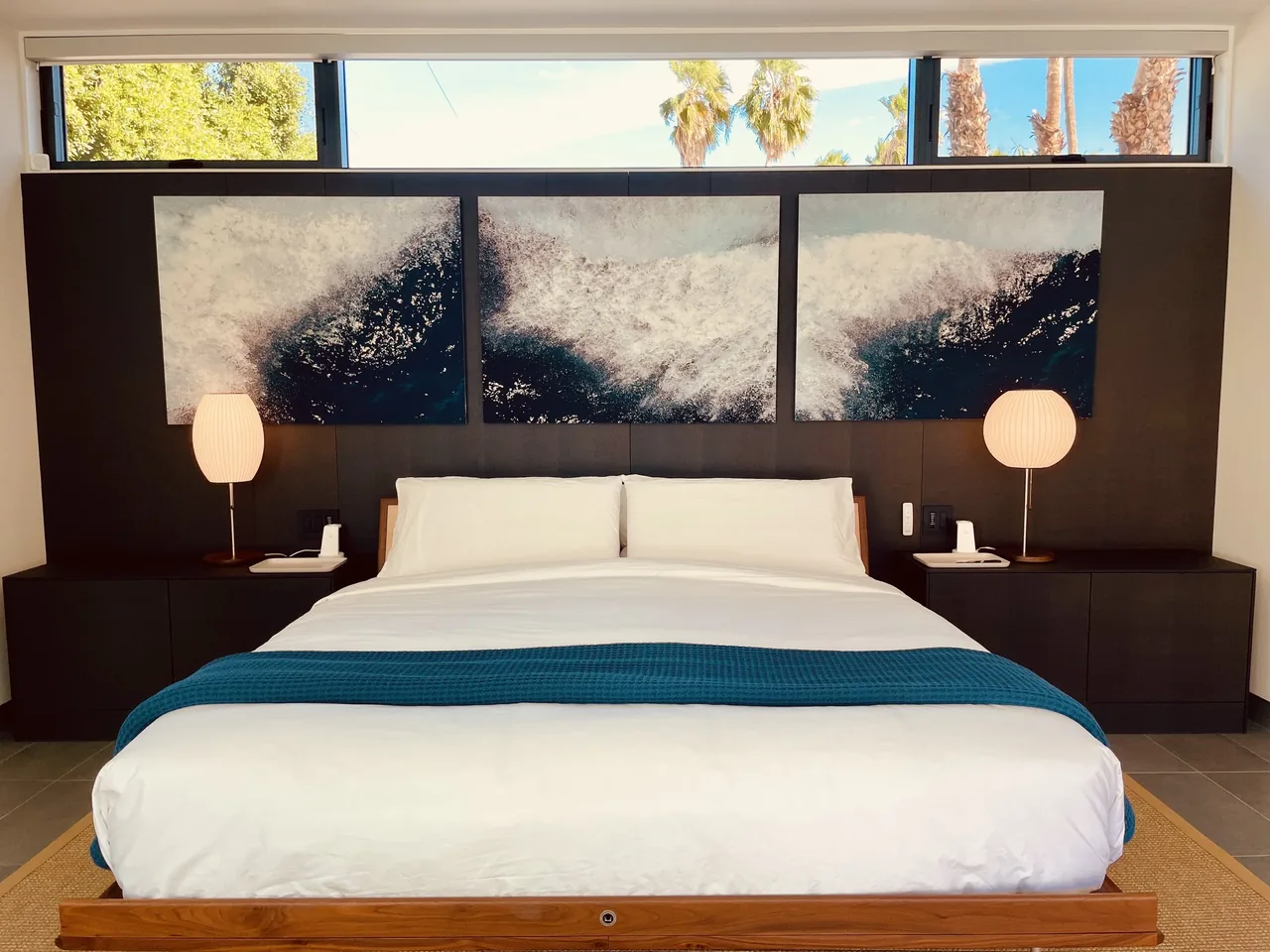 Modern bedroom with a horizontal high window and a triptych artwork above the bed in the PALM SPRINGS project.