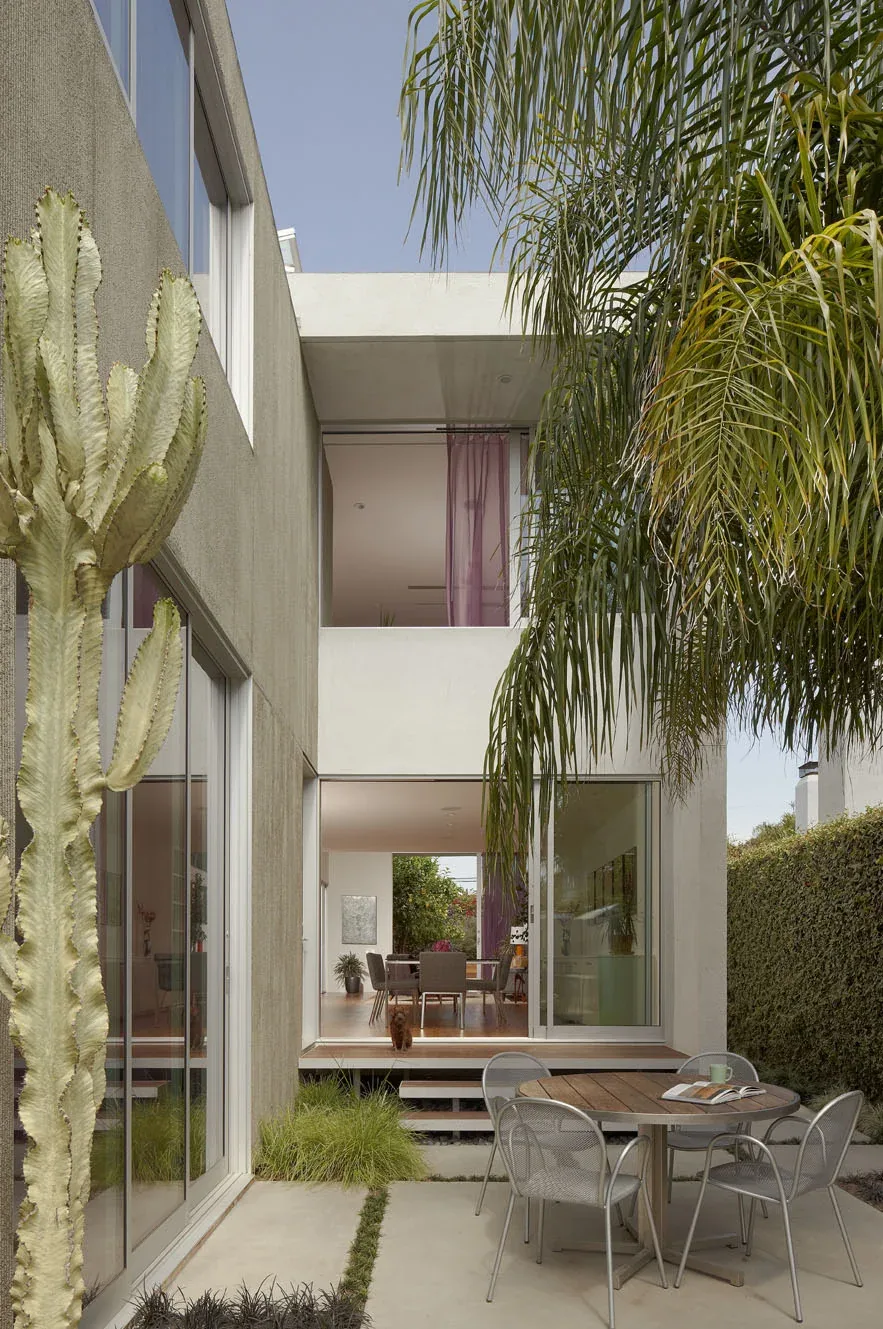 The NOWITA project by Carson Architects features an outdoor patio connected to the dining room with large glass sliding doors.