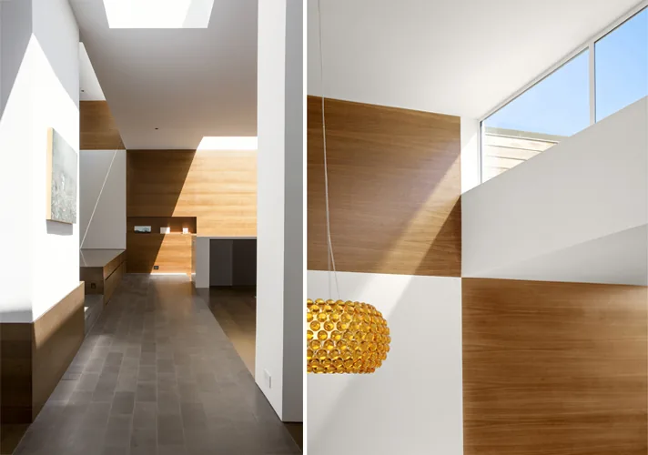Hill House interior shows stone floors, wood accent walls, and a gold pendant light near clerestory windows.