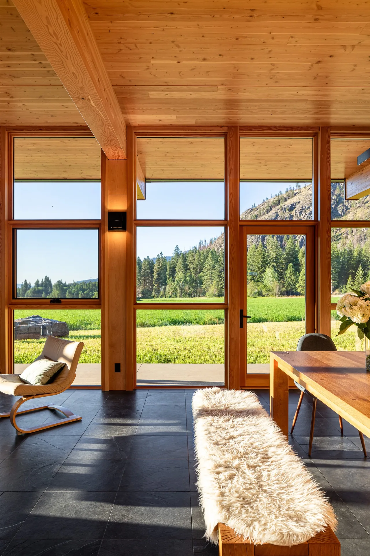 The Berm house features natural wood and large glazed panels that frame expansive outdoor views of fields and hills.