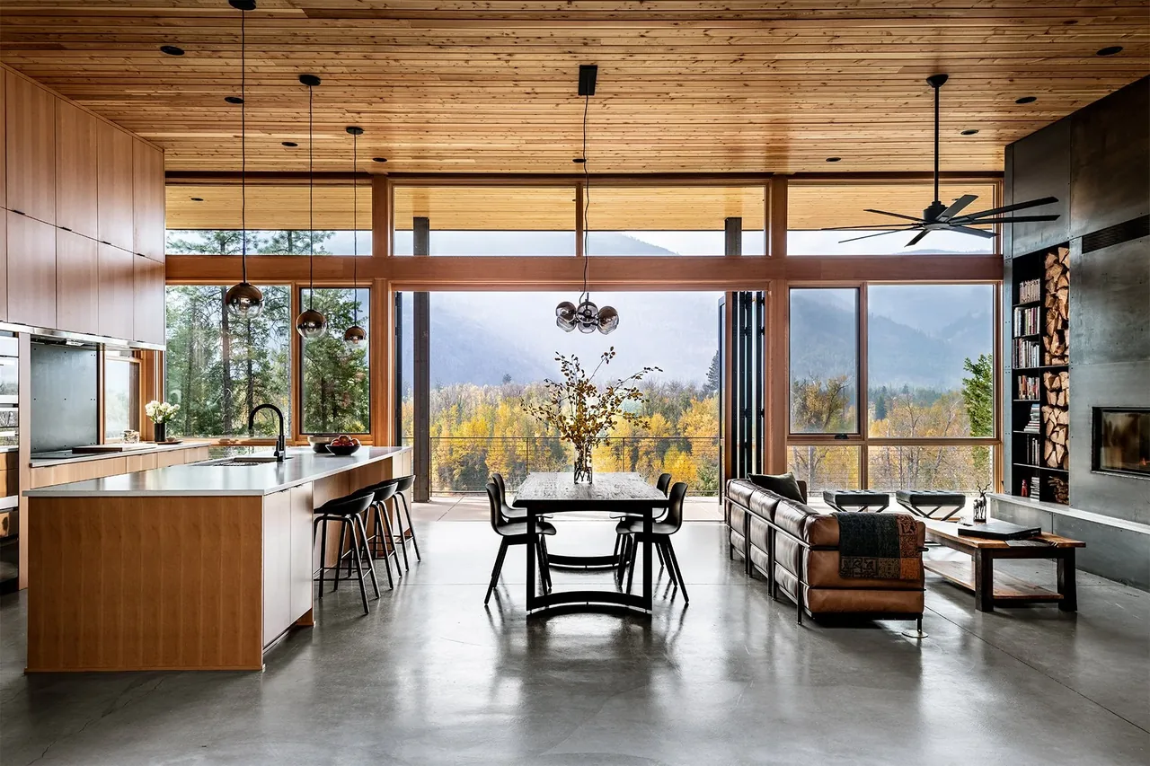 Edelweiss House open living and kitchen area with floor-to-ceiling glazing and a view of the mountains.