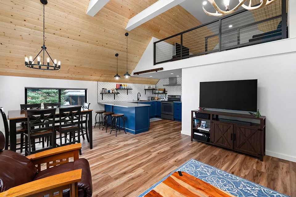 Open living and kitchen space with vaulted wood ceiling and black-framed windows from Crescent Beach remodel draft in Seattle.