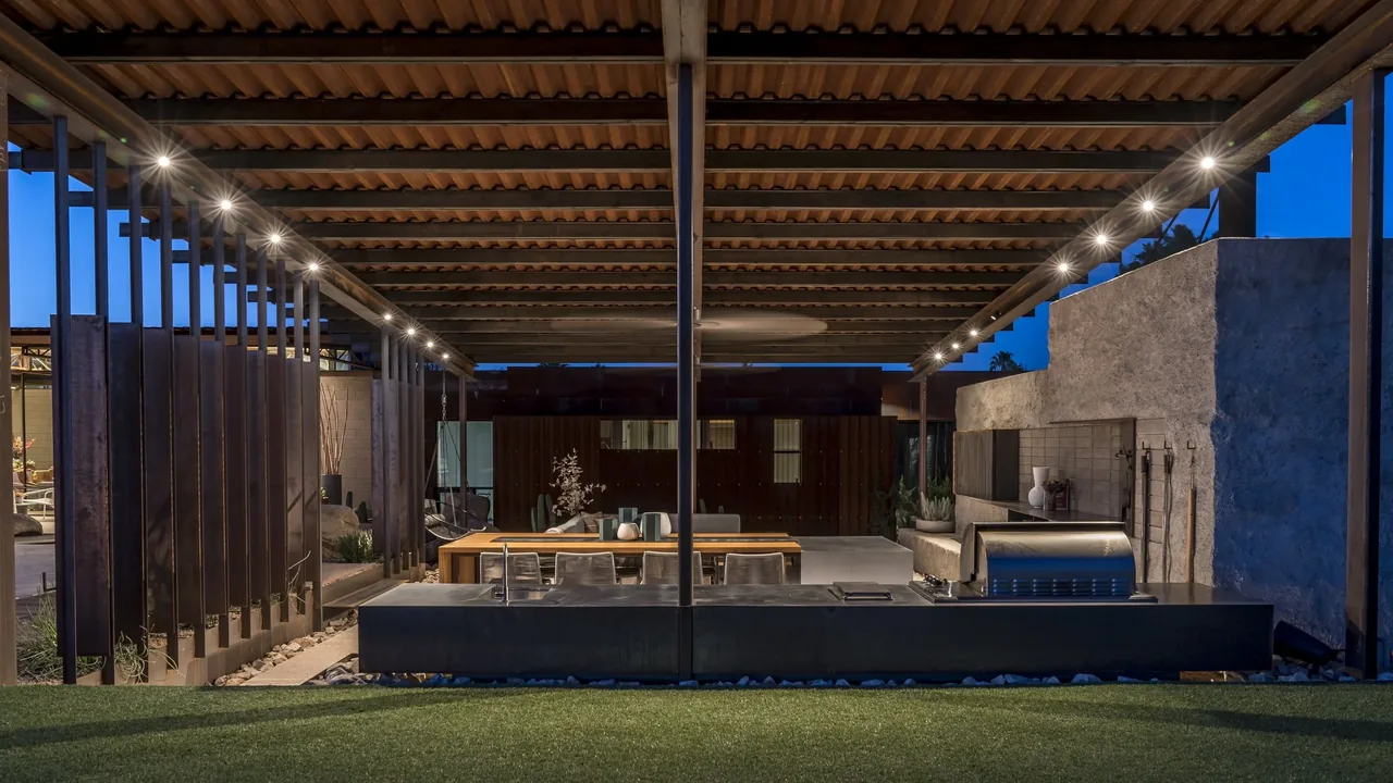 The 4018 casita features an outdoor dining and cooking area under a metal pergola roof with built-in grill.