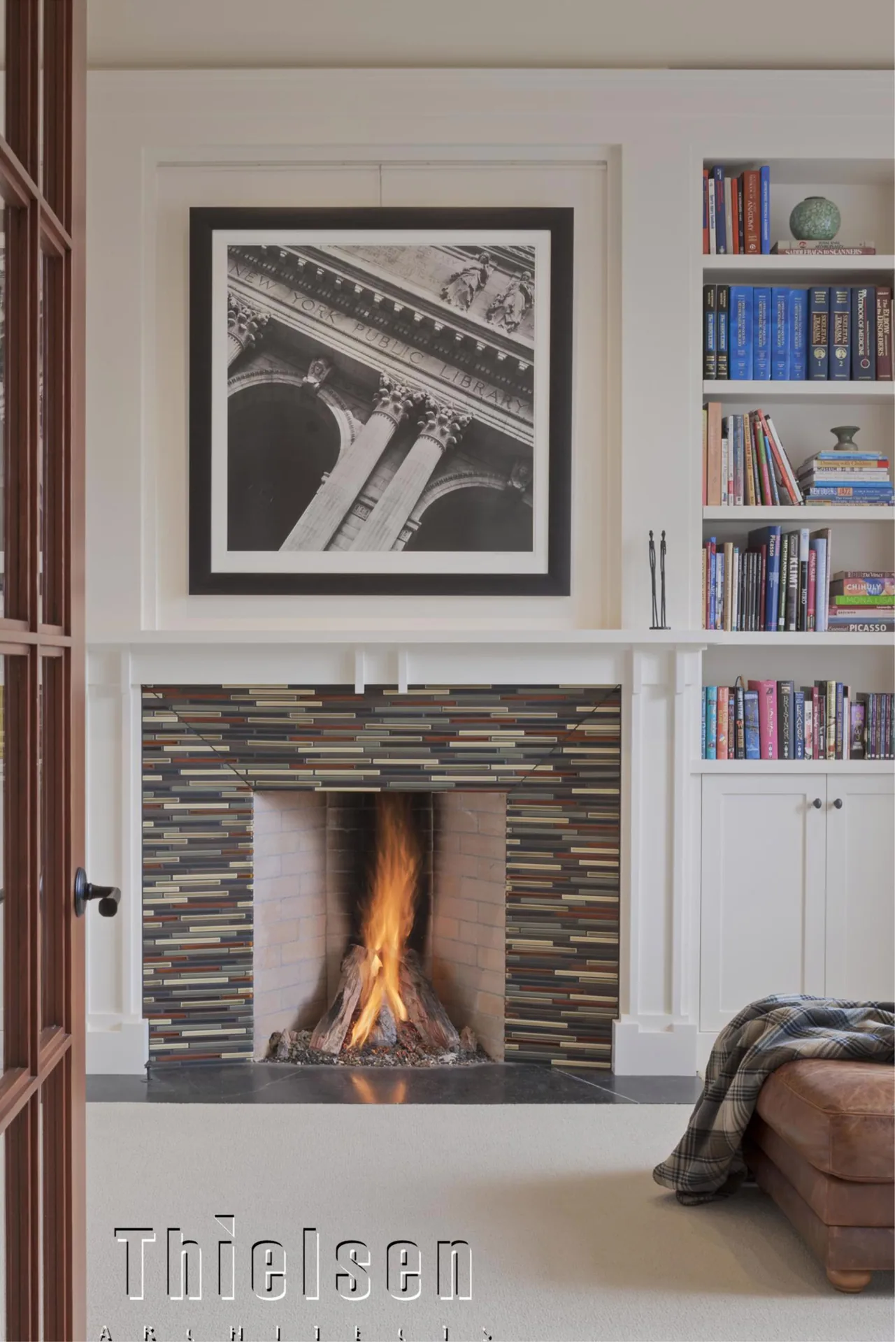 Roanoke Residence fireplace with multicolor tile surround, built-in bookshelves, and a large black-and-white photo above mantel.