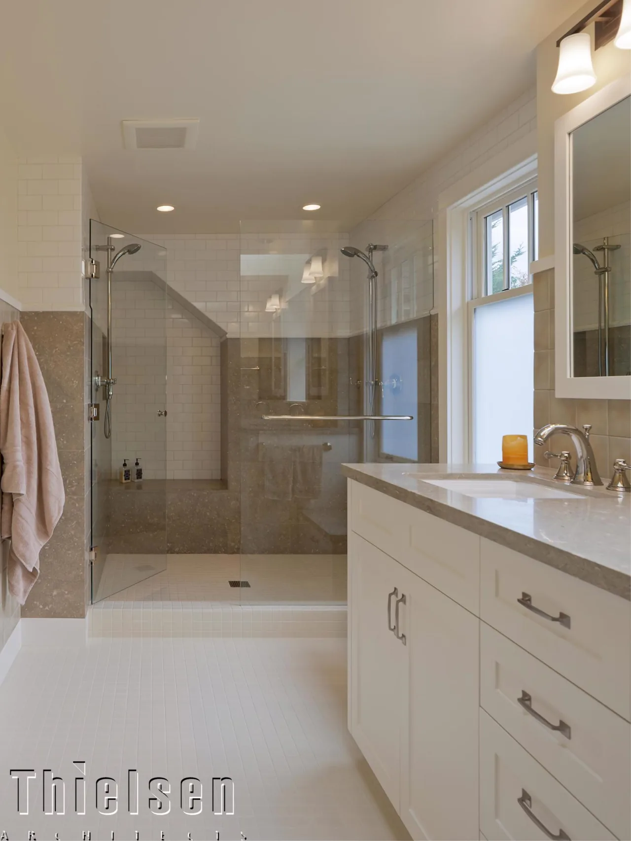 Bathroom with walk-in shower featuring glass doors, tiled walls, and a vanity with countertop and fixtures at Roanoke Residence.