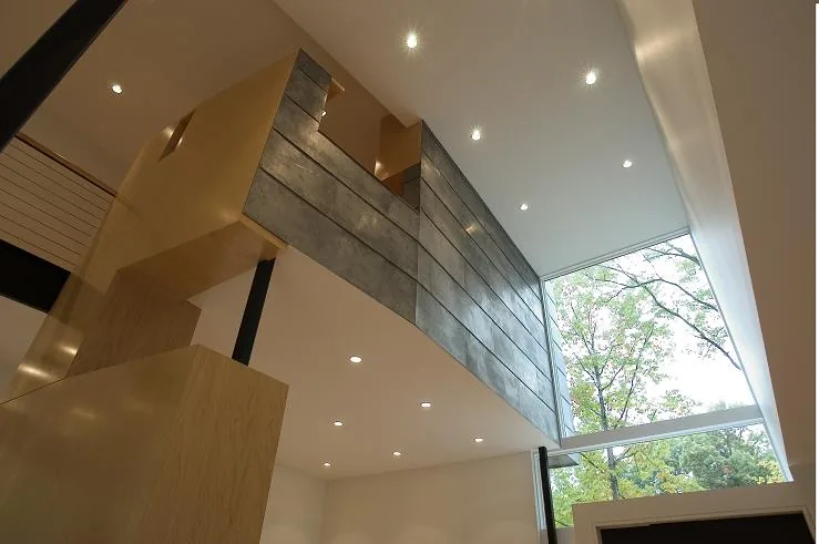 The Ceruti House features a spacious interior with large corner glazing and a blend of wood and concrete finishes.