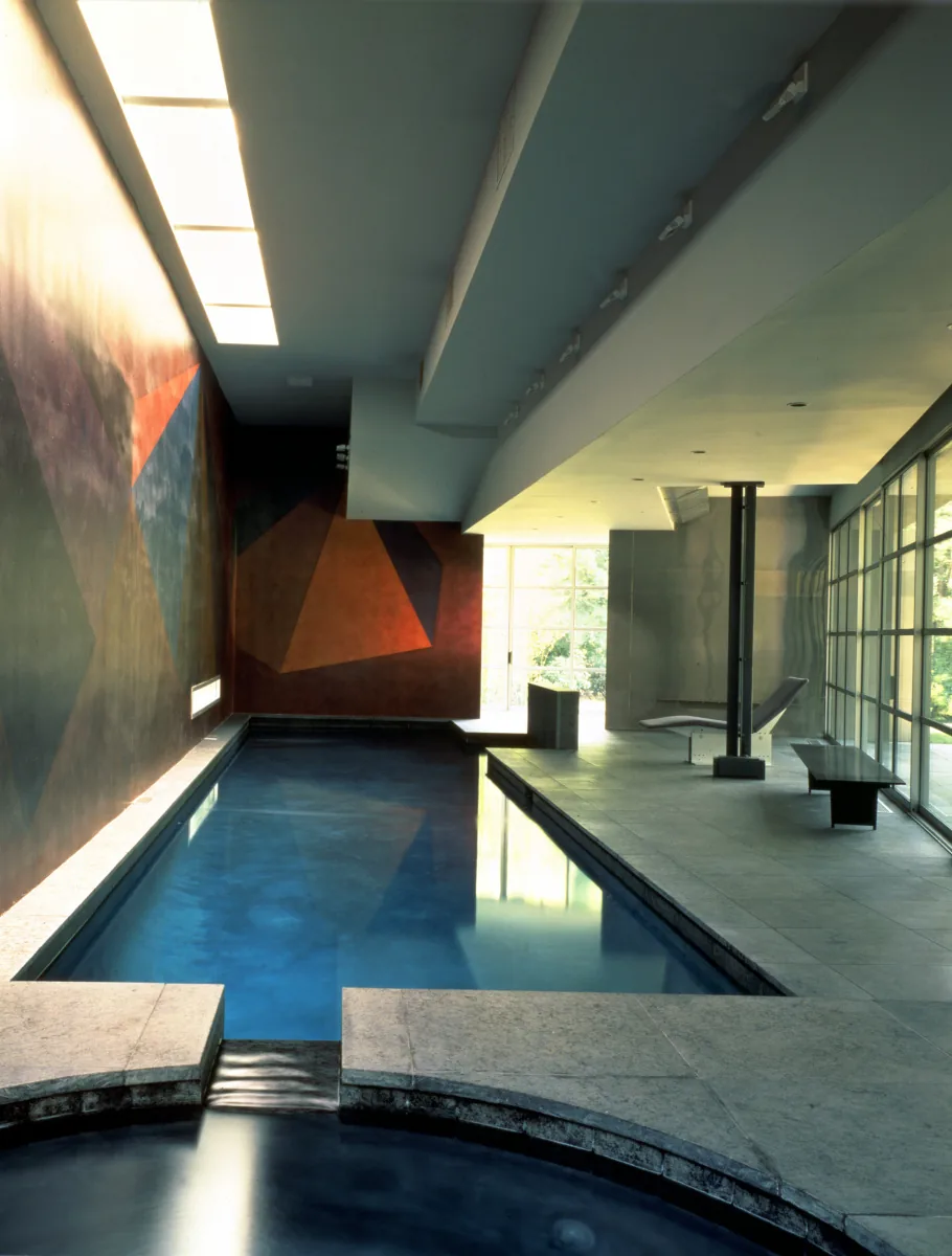 Indoor pool house interior with geometric mural, large grid window wall, and modern seating by Tod Williams Billie Tsien Architects.