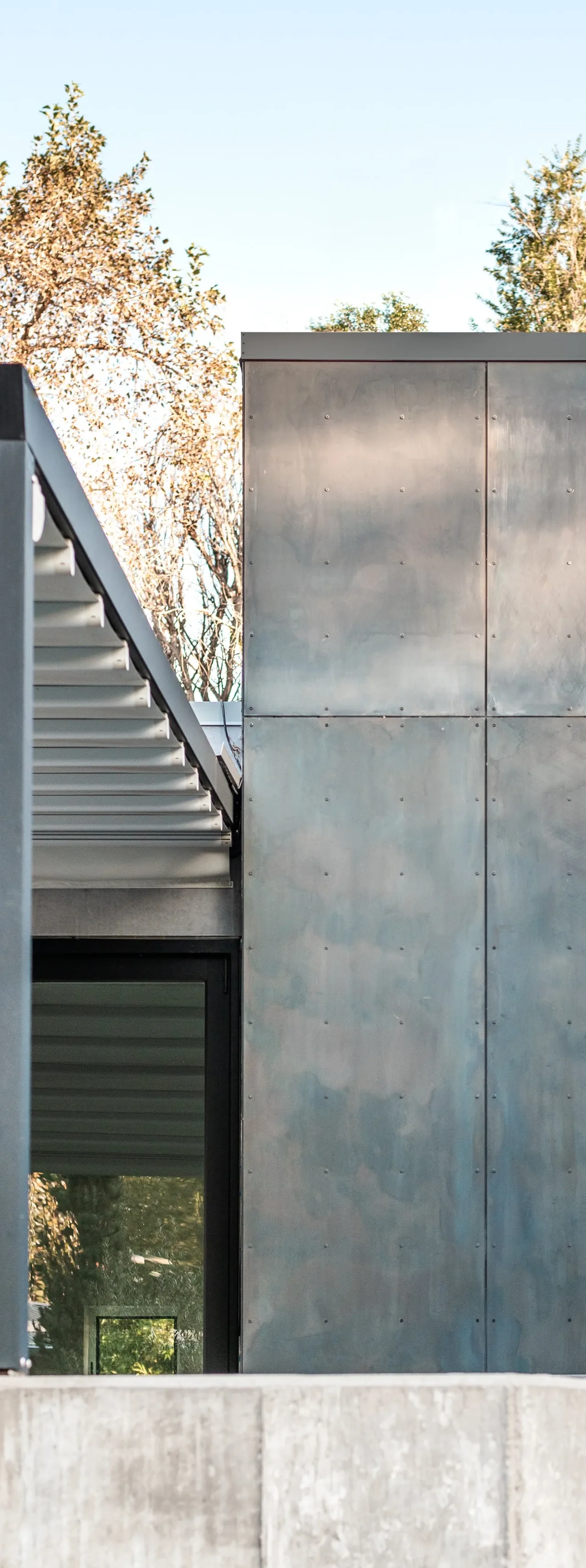 The JEFFERSON ST. RESIDENCE exterior shows metal panel siding and a metal overhang detail by Tomecek Studio Architecture.