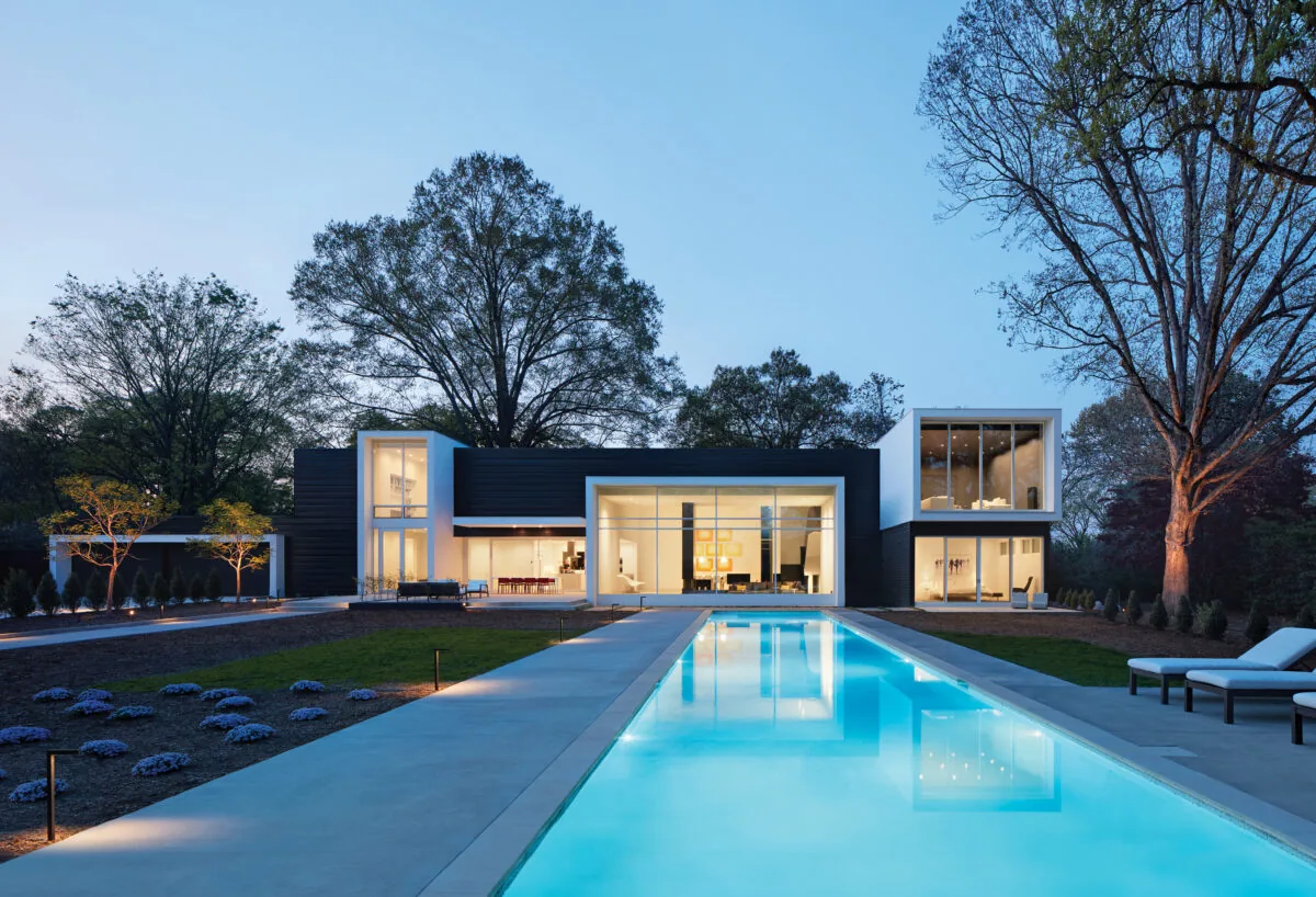 Frame House features a modern box structure with a vertical window tower and a long rectangular pool.