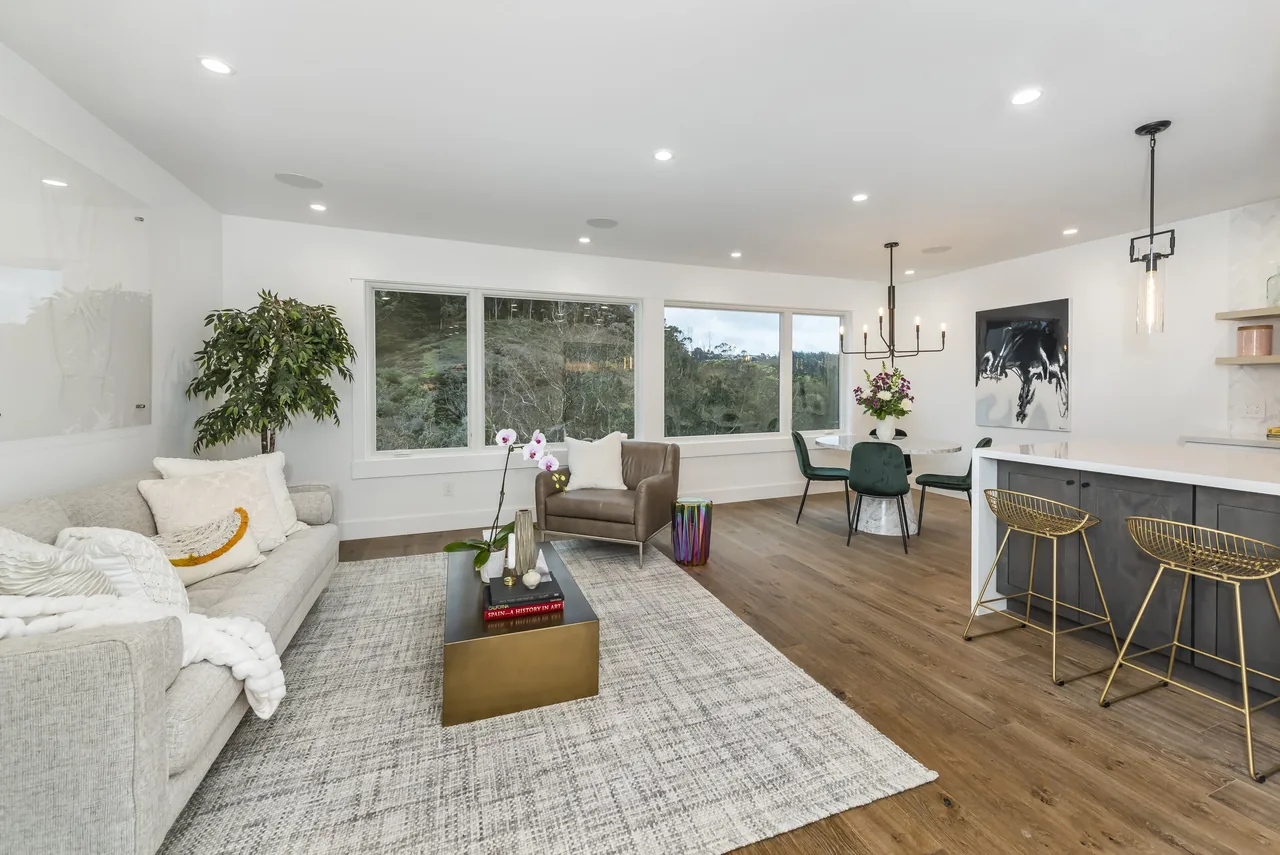 Forrest Edge project showcases an open living and dining space with expansive windows and contemporary finishes.